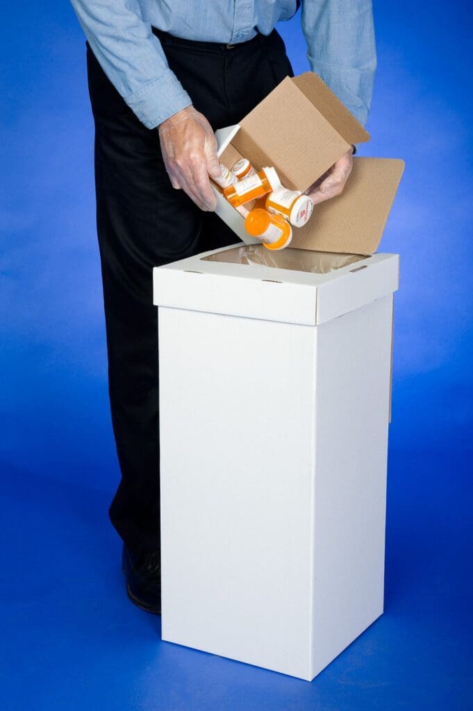 A person opening up a box on top of a white pedestal.