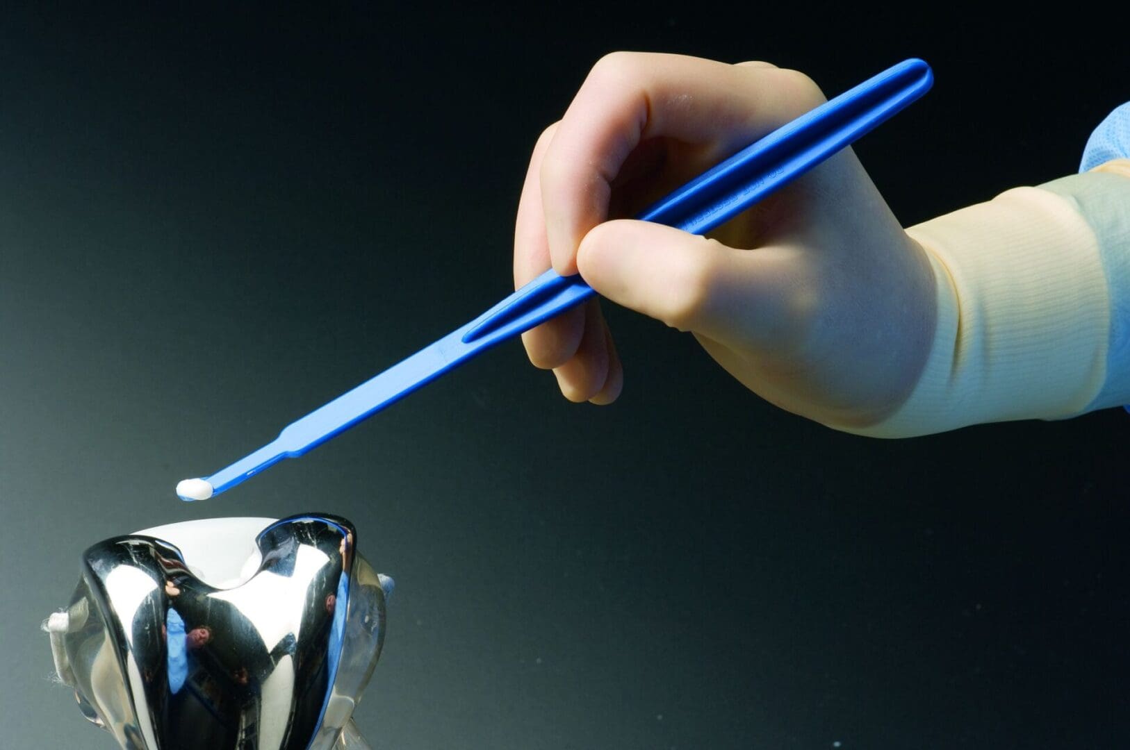A person holding a pair of blue chopsticks.
