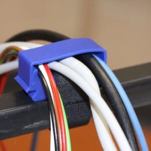 A blue plastic clip holding wires on top of a table.